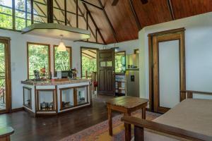a large living room with a kitchen and a table at Casa Leon in Talamanca +30 photos