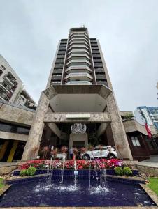 a tall building with a fountain in front of it at Flat no coração de Joinville in Joinville