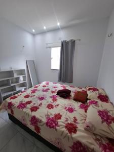 a bedroom with a large bed with flowers on it at Casa Lagoar in Jijoca de Jericoacoara