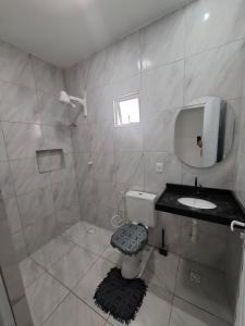 a bathroom with a toilet and a sink and a mirror at Casa Lagoar in Jijoca de Jericoacoara +10 photos