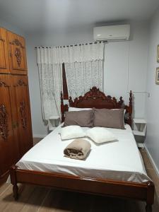 a bedroom with a large bed with a wooden headboard at Vinhas das Grutas in Soledade