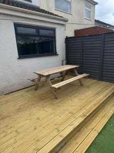 a wooden picnic table on a deck in front of a house at Victoria Park in Bristol