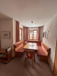 a dining room with a table and benches and a window at Ganda Appartements in Gargellen