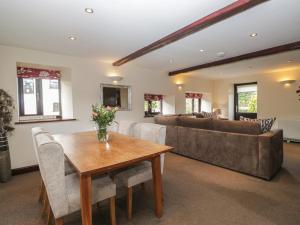 a living room with a table and a couch at Woodside Barn in Ulverston