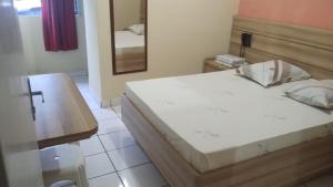 a bedroom with a large bed and a mirror at Hotel Styllus in São Paulo +8 photos