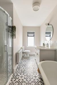 a bathroom with a tub and a toilet and a sink at The Wild Atlantic Townhouse in Enniscrone +29 photos