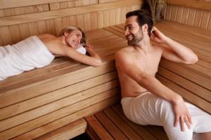 a man and woman sitting in a sauna at Hotel**Pieniny in Niedzica