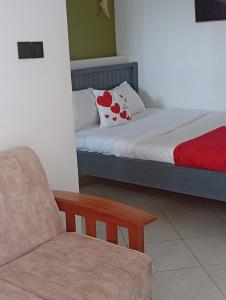 a bedroom with a couch and a bed and a chair at Shelvic Resort Ruiru in Ruiru