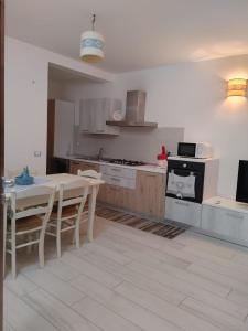 a kitchen with a table and chairs and a stove at Casa Dessi in Tanaunella +9 photos