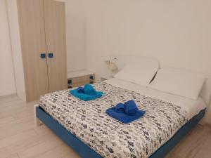 a bedroom with a bed with blue slippers on it at Casa Dessi in Tanaunella