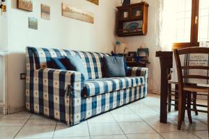 a blue and white couch in a living room at Seaside Beach House with Private Parking in Punta Marina