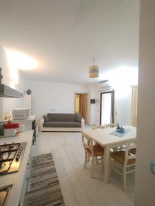 a kitchen and living room with a table and a couch at Casa Dessi in Tanaunella