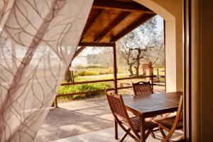 a table and chairs on a porch with a view of a yard at Agriturismo Il Querciolo in Grosseto