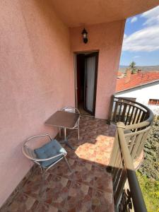 a balcony with a table and chairs on a house at Queen Apartmani in Soko Banja