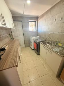 a small kitchen with a sink and a stove at Oasis terrenal Toconao in Toconao