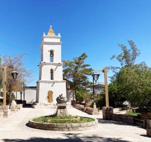 a church with a tower with a fountain in front of it at Oasis terrenal Toconao in Toconao