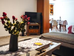 a living room with a vase of flowers on a table at Comfort Stay in Preveza
