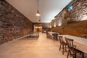 a room with tables and chairs and a stone wall at Red Stone in Kővágóörs