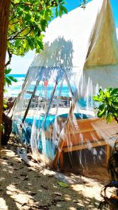a tent on the beach with the ocean in the background at Happybeach Sea view Cabin restaurant & beach bar in Tangalle +22 photos