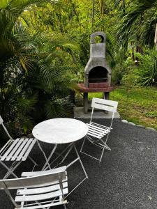 a table and two chairs and a table and a grill at Ti ÉMERAUDE in Pointe-Noire