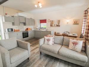 a living room with two couches and a kitchen at Carthouse in Weston-super-Mare