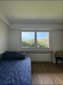 a bedroom with a bed and two windows at Cocon Élégant in Ettelbruck