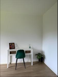 a white desk with a green chair in a room at Cocon Élégant in Ettelbruck