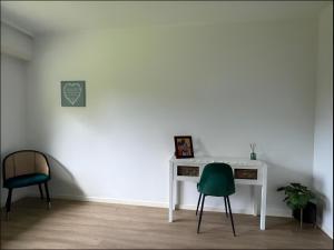 a white desk with a green chair in a room at Cocon Élégant in Ettelbruck