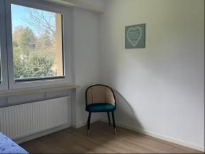 a chair in a room with a window at Cocon Élégant in Ettelbruck