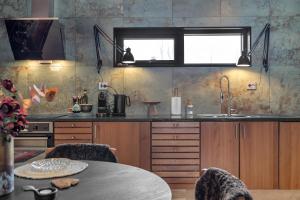 a kitchen with wooden cabinets and a table at Håkøya Lodge in Tromsø