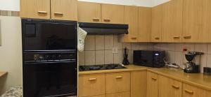 a kitchen with a black stove and a microwave at Applegate lodge in Clarens