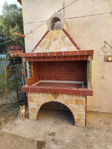 a brick oven with a cat sitting next to it at Olympus Sea View Apartment. in Nea Kallikrateia