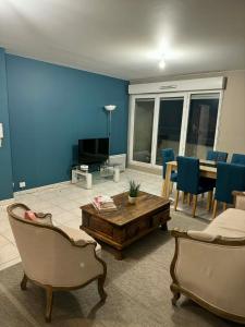 a living room with blue walls and a table and chairs at Apt Parisien in Vitry-sur-Seine