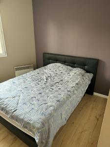 a bed with a blue comforter in a bedroom at Apt Parisien in Vitry-sur-Seine