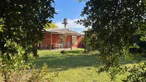 a red barn with a table in a yard at Casa El Roble in San Rafael