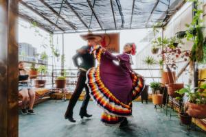 a man and woman dancing in a room with plants at Hostal Guadalajara in Guadalajara