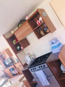 a kitchen with wooden cabinets and a stove top oven at Paddocks 4 in East Mersea +1 photo