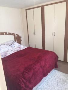 a bedroom with a bed and some white cabinets at Paddocks 4 in East Mersea
