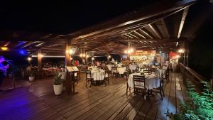 a dining room with tables and chairs and lights at Gran Lençóis Flat - Barreirinhas -MA in Barreirinhas