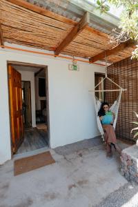 a woman sitting in a hammock in a house at Chill Atacama in San Pedro de Atacama
