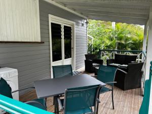 a patio with a table and chairs on a deck at Ti ÉMERAUDE in Pointe-Noire