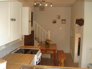 a kitchen with a stove and a table in a room at Fosbroke Cottage in Bidford