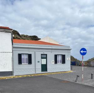 a white building with a green door on a street at Wavecrest in Horta