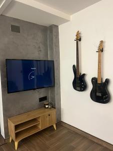 a living room with two guitars hanging on the wall at Lighthouse Apartman in Svilajnac +2 photos