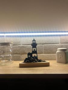 a wooden table with a lighthouse figurine on it at Lighthouse Apartman in Svilajnac