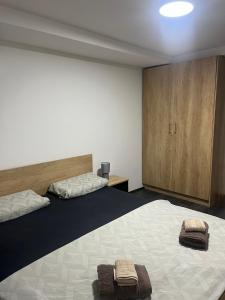 a bedroom with two beds with towels on them at Lighthouse Apartman in Svilajnac