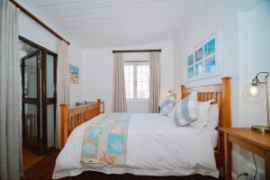 ein Schlafzimmer mit einem Bett mit weißer Bettwäsche und einem Fenster in der Unterkunft Katonkel in Paternoster + 20 Fotos