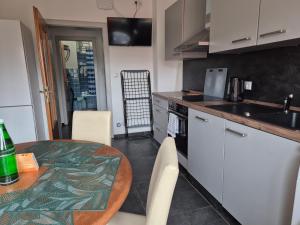 a kitchen with a wooden table and a kitchen with white cabinets at Monteurwohnung Biedenkopf in Biedenkopf