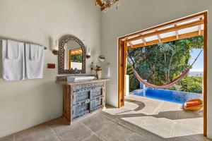 a bathroom with a mirror and a sink and a window at Ocio Villas Mal Pais in Santa Teresa Beach +81 photos