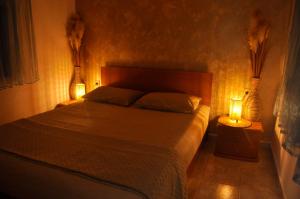 a bedroom with a bed with two lamps on it at Georgias house in Yerakiní
